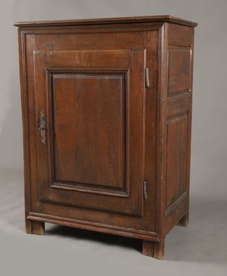 une vieille armoire en bois avec une porte et un tiroir au-dessus