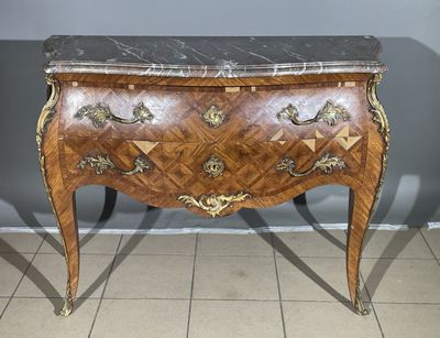 a small chest of drawers with a marble top