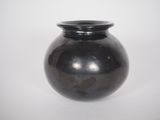 a black vase that is sitting on a white surface