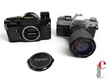 two cameras sitting next to each other on a white surface