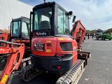 a red and black tractor parked in a parking lot