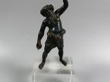 figurine en bronze représentant un garçon lançant une balle, posée sur un socle en acrylique transparent