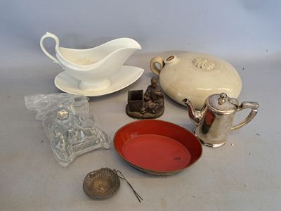 une table sur laquelle sont posés divers objets, notamment un bol, une soucoupe, une théière, une théière et d'autres objets