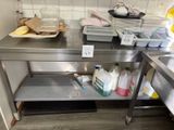 une table de travail en acier inoxydable sur laquelle se trouvent de nombreux produits d'entretien