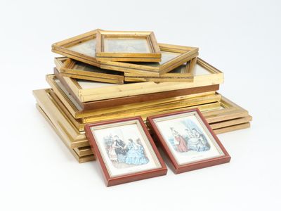 a pile of framed pictures on a white surface