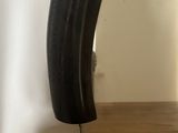 a black vase sitting on a wooden table next to a mirror