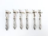 six cuillères en argent avec manche, posées sur un fond blanc