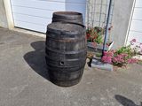 a large wooden barrel sitting in front of a garage
