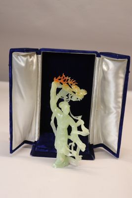 une figurine en verre représentant une femme tenant une fleur à la main