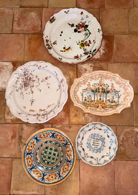 quatre assiettes posées par terre, ornées de motifs différents