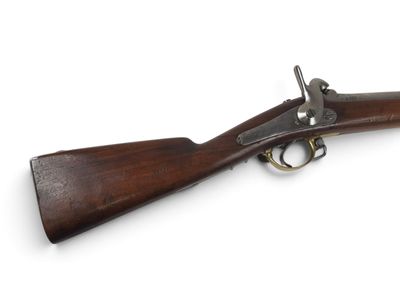 un vieux fusil avec un canon en bois et des accessoires en laiton sur fond blanc