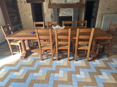 une table et des chaises dans une pièce avec une cheminée en arrière-plan