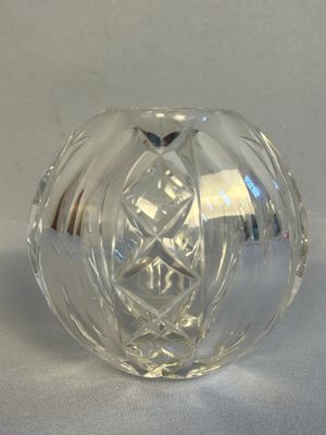 un objet en verre transparent posé sur une surface blanche