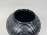 a black vase that is sitting on a table