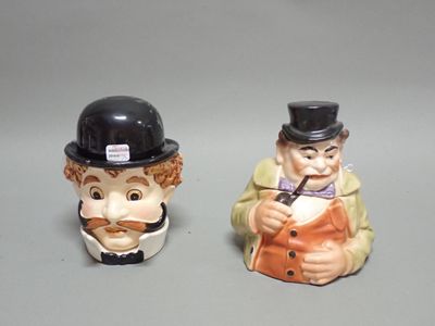deux figurines représentant un homme et une femme portant un chapeau et un frac