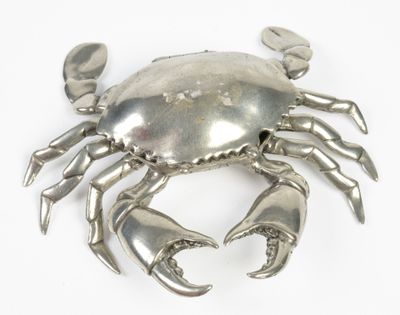 a silver crab that is sitting on a white surface