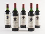 four bottles of wine are lined up in a row on a white surface
