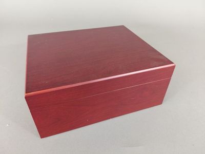 une petite boîte en bois avec un couvercle sur une surface blanche