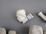 a lot of clay heads and a pipe sitting on a table