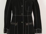 manteau en laine noire avec des coutures et des boutons blancs, présenté sur un mannequin sur pied