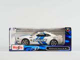une voiture de police miniature dans une boîte, posée sur une surface blanche