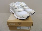 une boîte sur laquelle est posée une paire de chaussures blanches