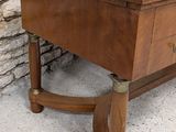 a wooden table with a glass top on a stone floor