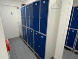several blue lockers are lined up in a row in a bathroom