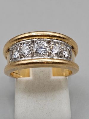 gros plan d'une bague en or et diamants sur une surface blanche