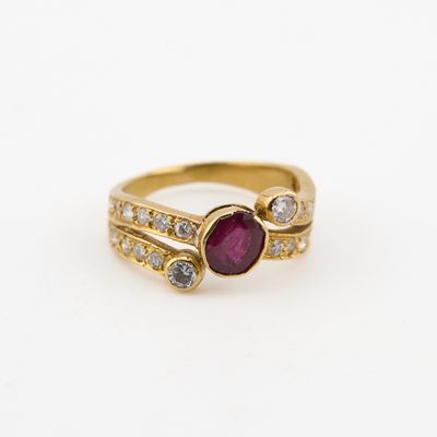 gros plan d'une bague en or avec un rubis et des diamants