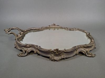 un plateau en argent richement décoré, surmonté d'un miroir