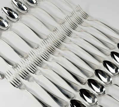 de nombreuses fourchettes et cuillères alignées sur une table