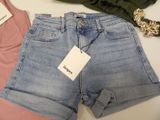 two pairs of shorts and a tank top on a table