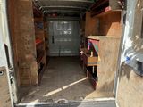 a white van that has a door open and shelves in the back