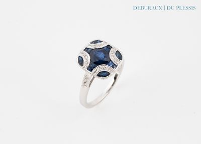 gros plan d'une bague avec un saphir bleu et des diamants
