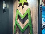 a wooden sign with a green m on it