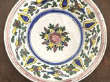une photo d'une assiette décorée d'un oiseau et de fleurs