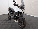 une moto qui est garée dans une pièce dont le sol est en damier