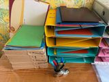 a stack of folders on a desk next to a computer monitor