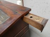 un bureau en bois muni d'un tiroir sur lequel se trouve un bouton