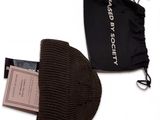 un chapeau marron et un sac noir sur fond blanc