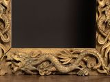 a gold picture frame with a dragon and flowers on it