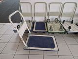 four luggage carts sitting next to each other on a tiled floor