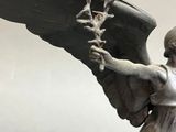 a statue of an angel holding a flower in its hand