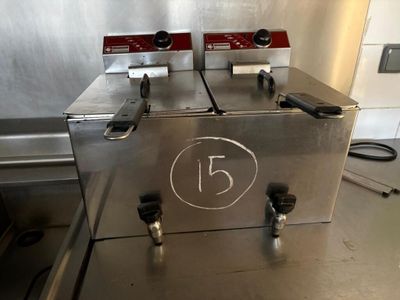 two deep fryers sitting on a counter in a kitchen