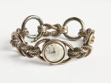 une image d'un gros plan d'une montre-bracelet sur une surface blanche