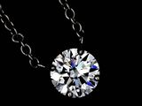 a close up of a diamond on a chain on a black background