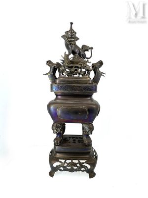 a metal vase that has a bird on top of it