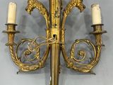 an antique wall sconce with two candles and a bird on it