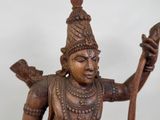a wooden statue of a man holding a staff